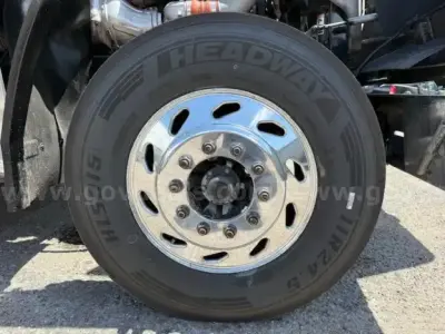 Wheel and tire close-up on Freightliner Coronado truck showing Headway tire with alloy hub and lug nuts.