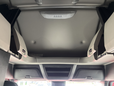 Cab interior of a Freightliner truck showing overhead compartments and sun visor area.