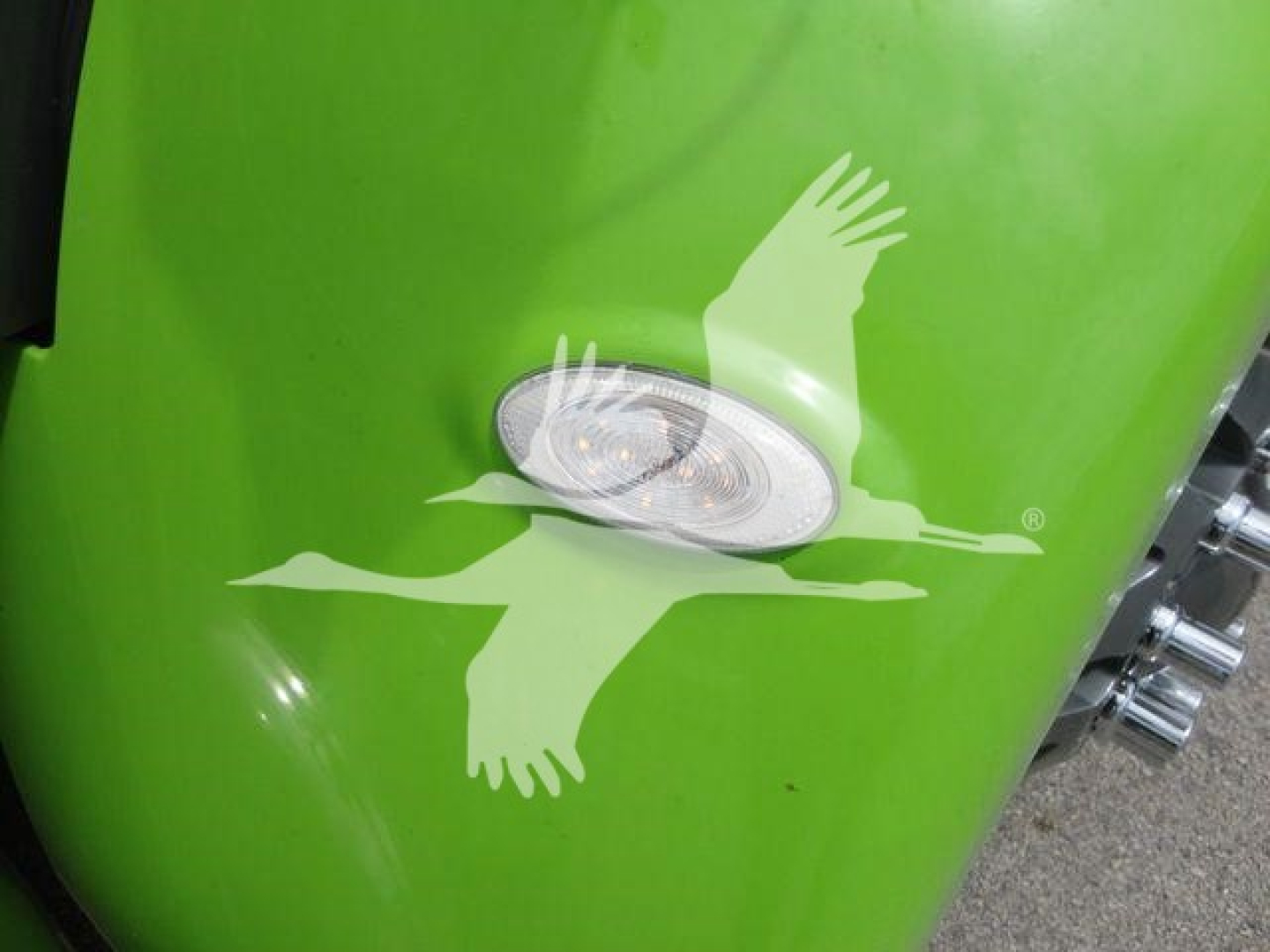 Green Peterbilt truck fender with a white flying eagle decal and a side marker light visible.
