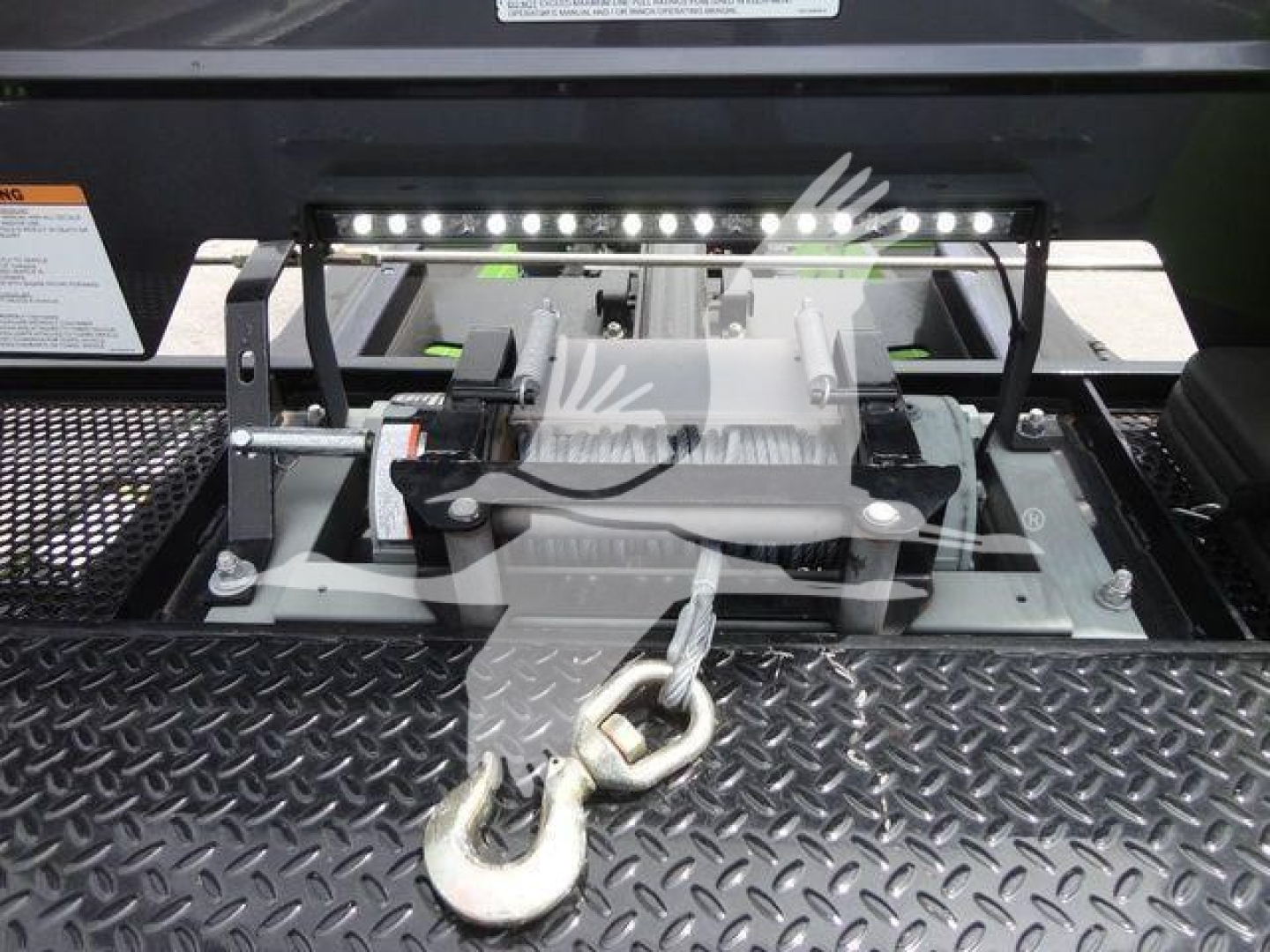 Peterbilt 337 rollback truck hitch and latching mechanism visible in bay with chain and hook attachment.