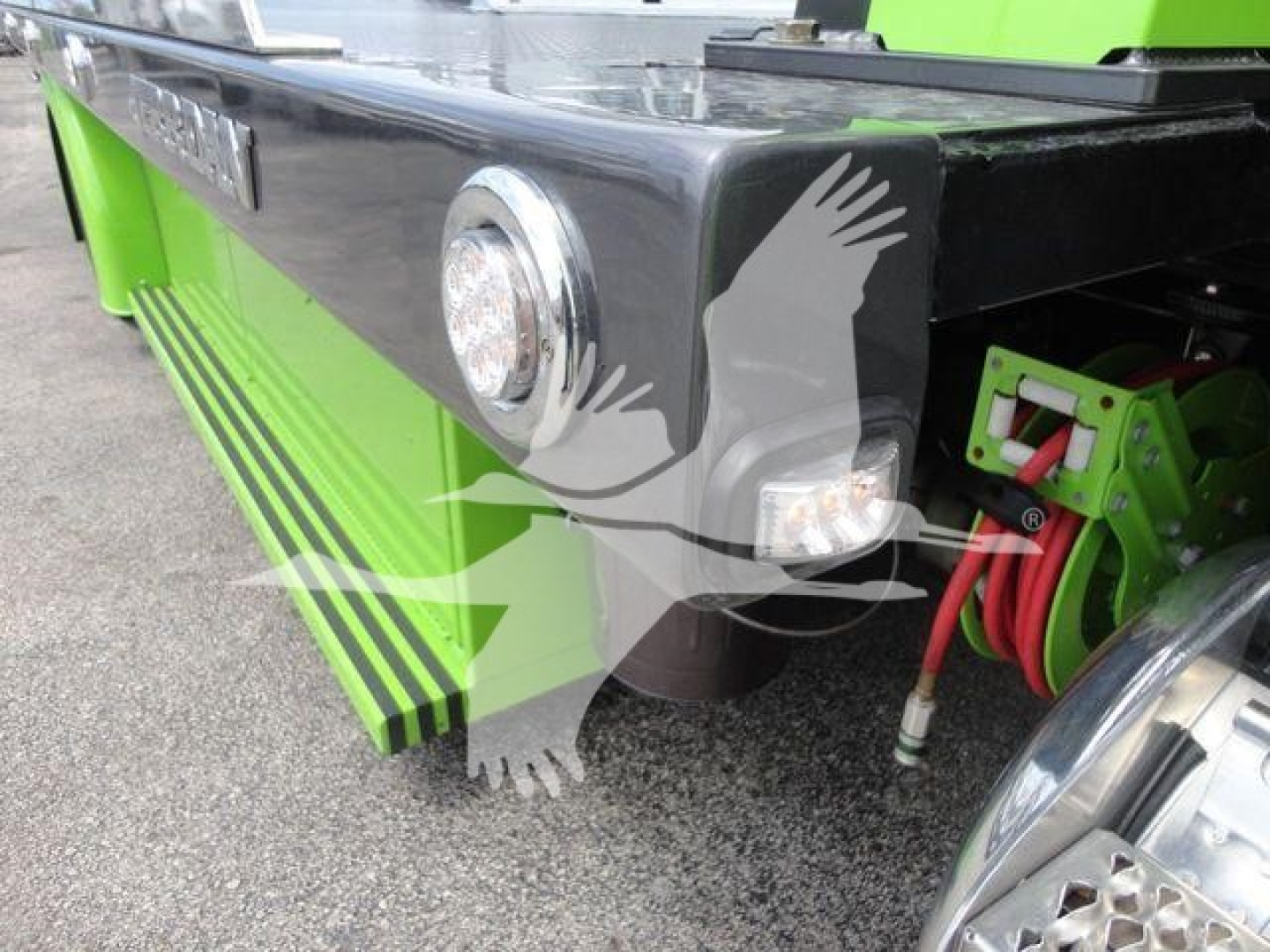 Peterbilt 337 rollback truck rear side with lime green accents, fuel/air lines, and rear fender; visible round rear light and side cab step.