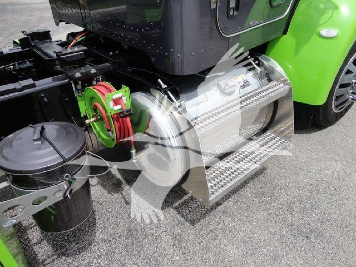 Peterbilt 337 step side with polished aluminum fuel tank and chrome step, green chassis, hitch mechanism, and air lines visible