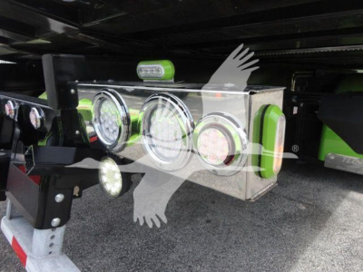 Trucks undercarriage showing a polished metal toolbox with multiple round gauges and green accents mounted on a Peterbilt 337 rollback truck.
