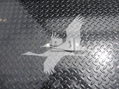 Metal diamond-plate surface with a small metal mounting bracket in foreground.