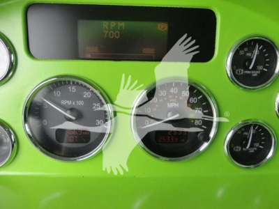 Dashboard gauges and digital display in a lime-green Peterbilt truck showing RPM 700, MPH gauge, and various dials.