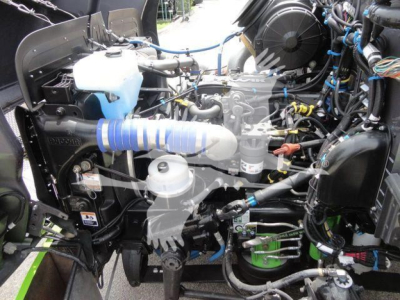 Peterbilt 337 engine bay showing coolant reservoir, intake piping, hoses, and other engine components.