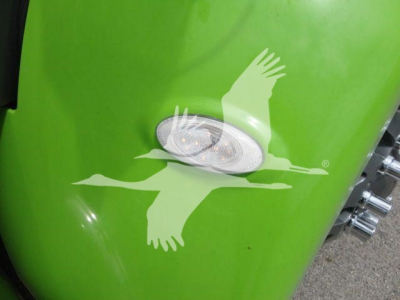 Green Peterbilt truck fender with a white flying eagle decal and a side marker light visible.