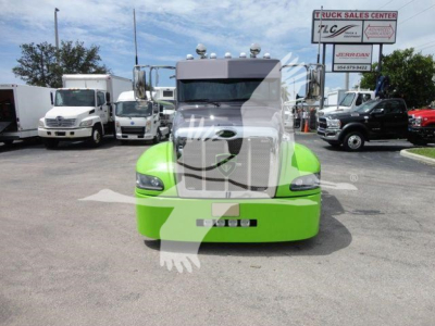 Front view of a bright green Peterbilt 337 truck in a dealership lot.