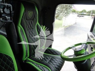 Peterbilt 337 cab interior showing green and black diamond-stitched seats and green steering wheel.