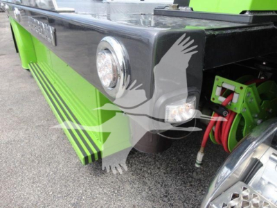 Peterbilt 337 rollback truck rear side with lime green accents, fuel/air lines, and rear fender; visible round rear light and side cab step.
