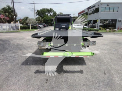 Peterbilt 337 rollback tow truck rear view showing loading platform and neon green rear bumper safety bar.
