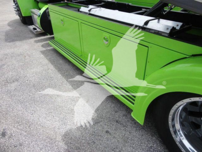 Green Peterbilt 337 side view showing storage compartments on the lower side panel and black steps; wheel with polished rim partially visible.