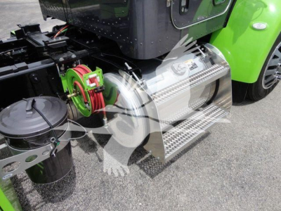 Peterbilt 337 step side with polished aluminum fuel tank and chrome step, green chassis, hitch mechanism, and air lines visible