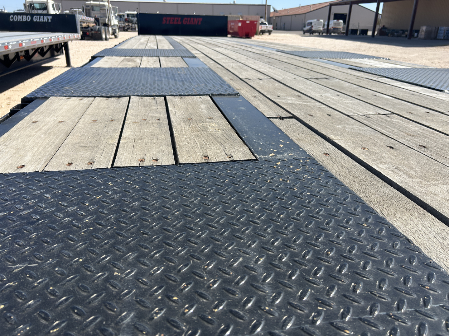 Trailer deck showing wood planks and diamond-plate tread sections on a Dorsey DF48 60 Ton trailer.