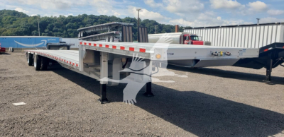 New 2027 Reitnouer Big Bubba dropdeck trailer showing side rails and support legs with reflective tape and VIN sticker
