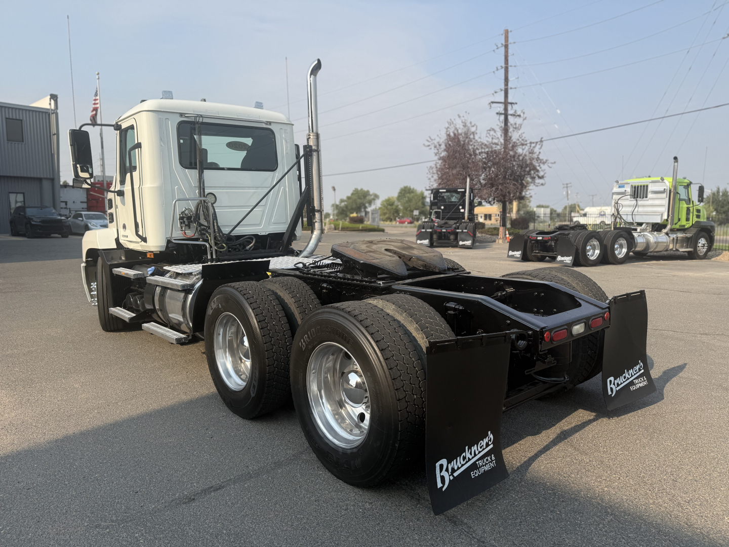 Truck chassis of a 2020 Mack Anthem daycab with dual rear axles and mud flaps labeled Braden's Transport; white cab, black chassis, several wheels, parking lot.