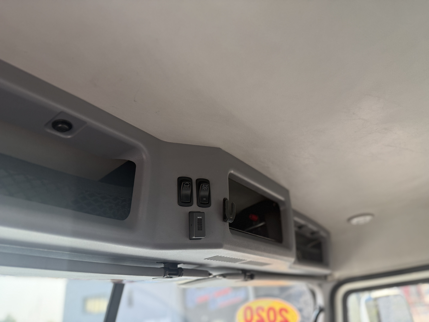 Interior overhead controls and sun visor area of a 2020 Mack Anthem daycab truck showing switches and a small window/dome in the overhead console.
