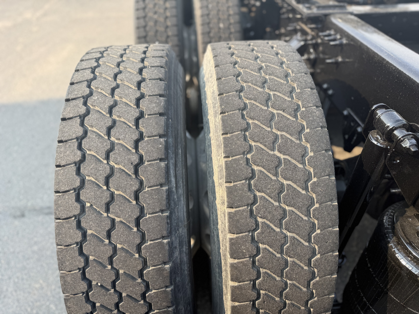 Dual rear axle tires on a Mack Anthem truck showing tread pattern and part of frame.