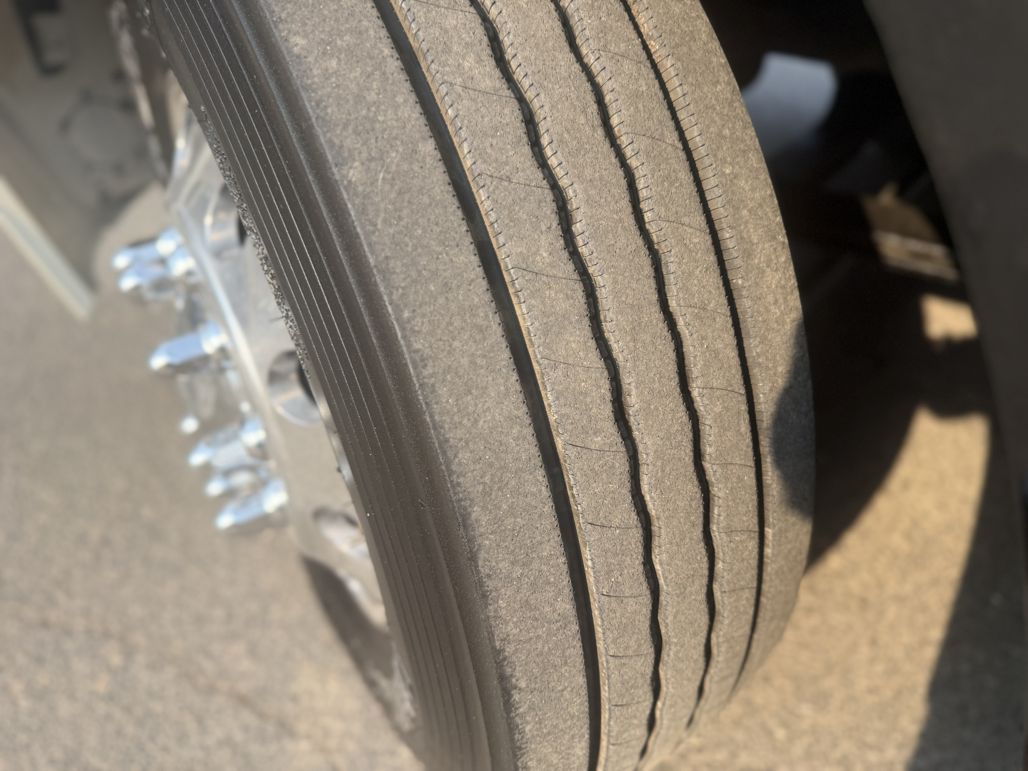 Front tire and wheel of a 2020 Mack Anthem daycab truck showing tread and wheel bolts.