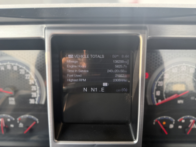 Dashboard display showing vehicle totals: mileage 138,929 mi; engine hours 1657.5?; time in service 243d 20h 56m; fuel used 2197 gal; highest RPM 2300; N N1 . E on screen.