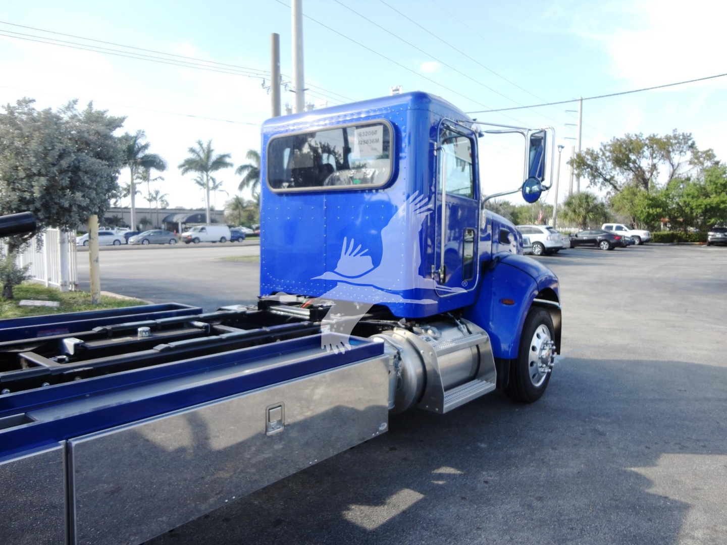 Peterbilt 337 Rollback truck, blue cab, rear view showing chassis and flatbed, side mirror, and windows.