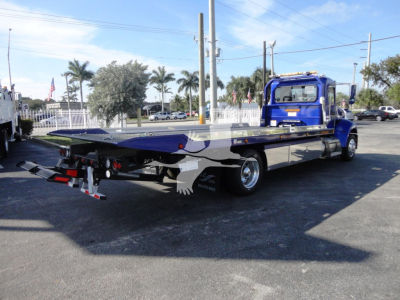 Peterbilt 337 rollback truck shown from rear-left side with flatbed and tow equipment.