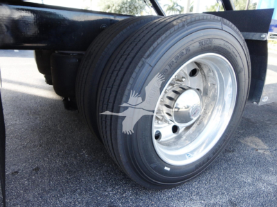 Peterbilt 337 truck wheel and front suspension with chrome rim and tire, undercarriage visible.