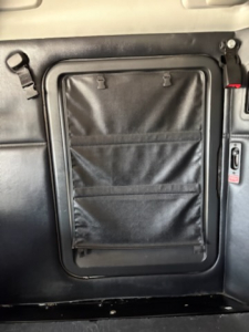 Kenworth T680 cab interior side door pocket with storage pouches and latch shown.