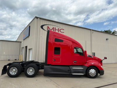 Kenworth T680 tractor in red, side view showing sleeper cab, dual rear axles, and chassis; no visible text on decals.