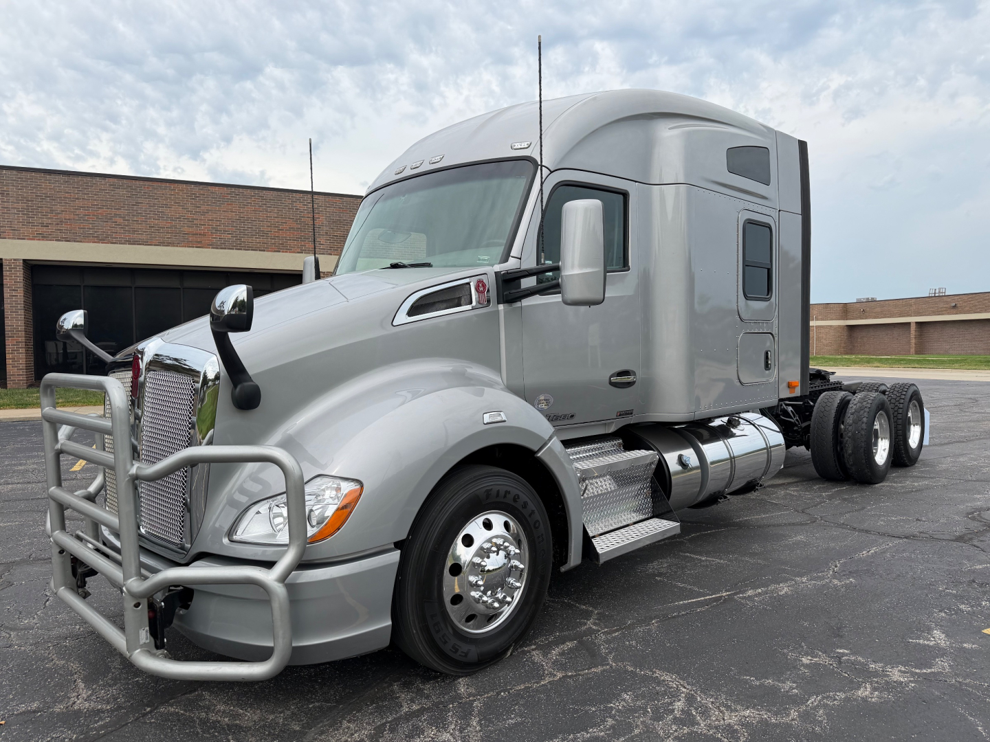 Kenworth T680 highway-tractor side view showing sleeper cab, chrome wheels, front grille guard, dual rear axles, and chrome fuel tanks.
