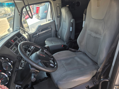 Kenworth T680 truck cabin interior showing steering wheel, driver's seat, and dashboard with gauges.