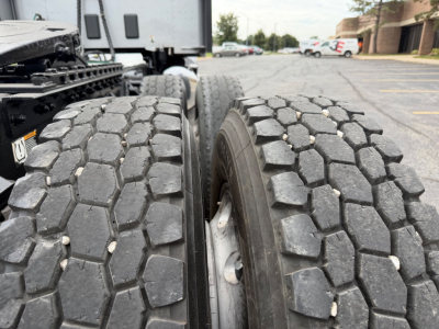 Truck rear dual tires on a 2018 Kenworth T680 showing heavy tread blocks and wheel rims.
