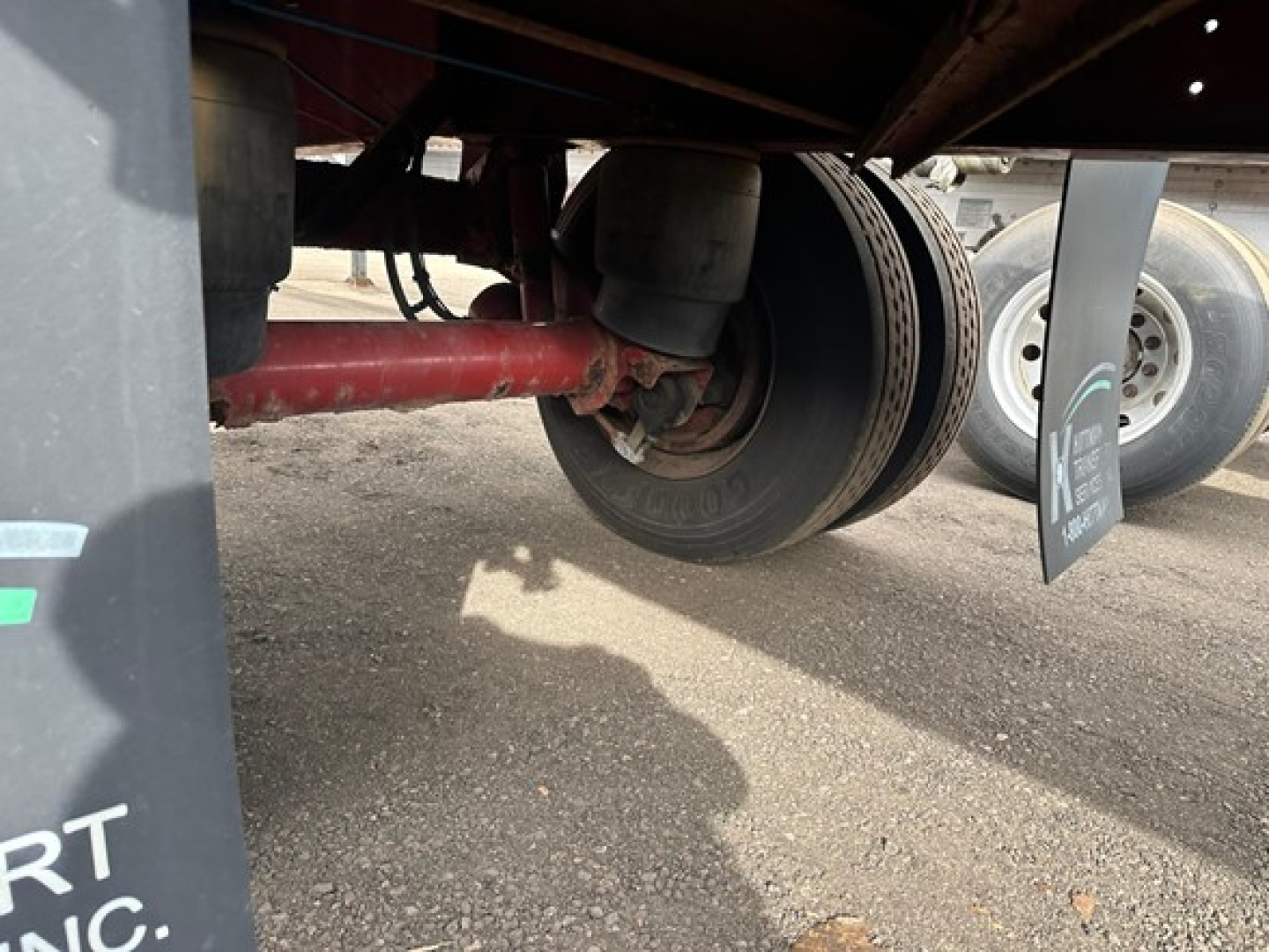 Trailer wheel and undercarriage showing tandem axle and suspension components for a Fontaine Infinity flatbed trailer.