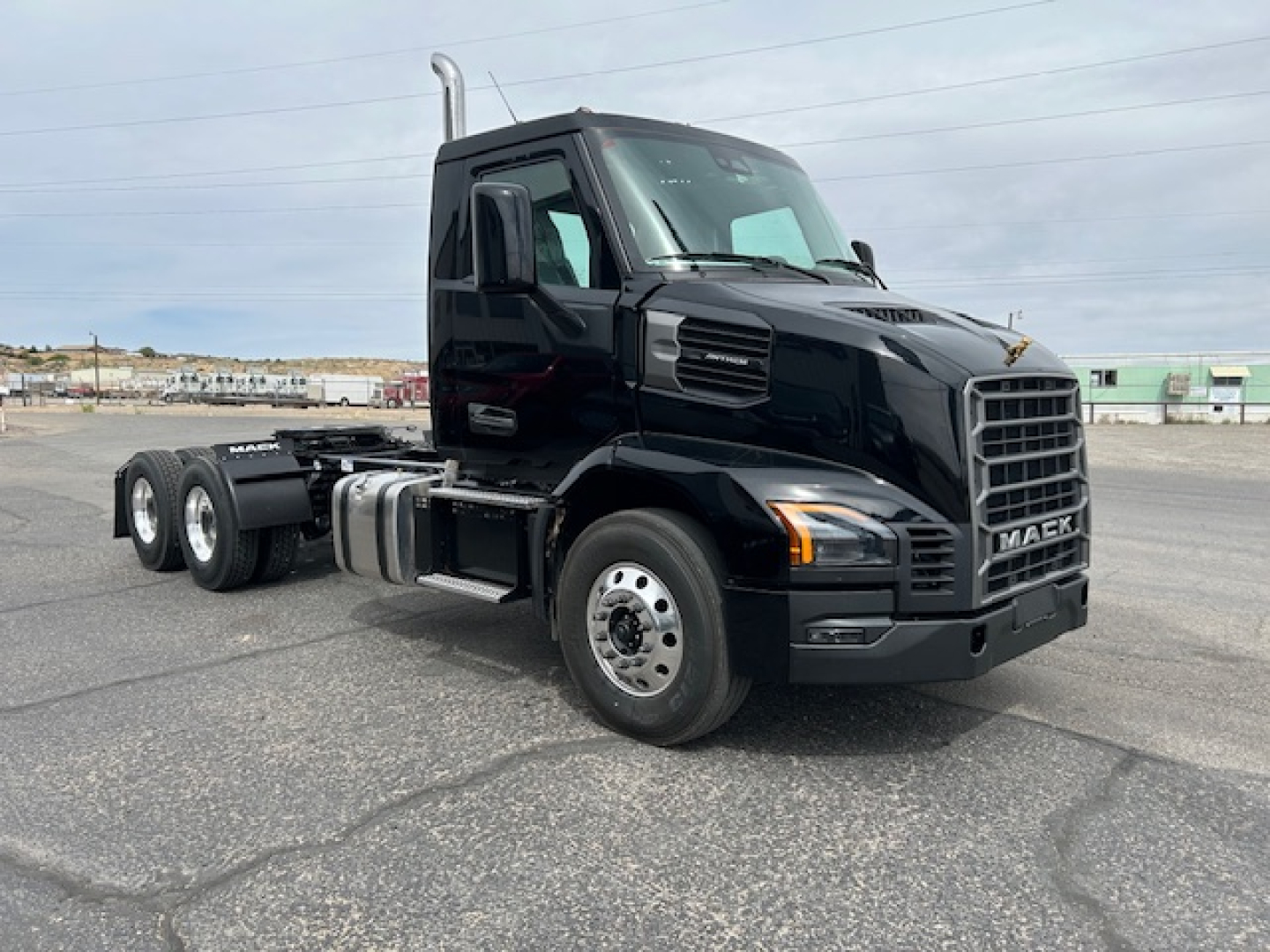 Mack AN64T conventional daycab truck in black, front three-quarter view showing cab and chassis with dual rear axles and MACk grille.
