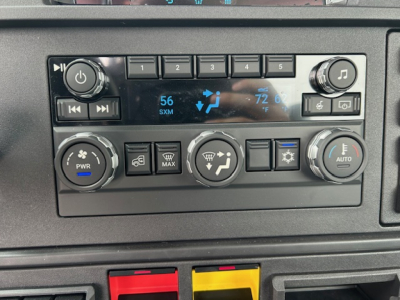 Truck climate control panel and dashboard of a 2027 Mack AN64T showing control knobs, buttons, and digital display.
