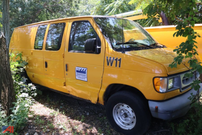 Ford E150 cargo van in-service showing W11 marking and a side sticker.