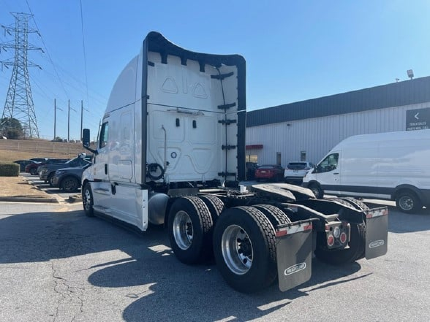 Freightliner Cascadia 126 truck cab and rear view showing sleeper cab, dual rear axles, and fifth-wheel area with mud flaps.