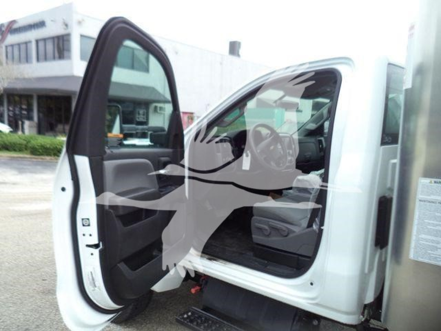 Chevrolet Silverado 6500HD cab interior with front door open in a showroom setting.
