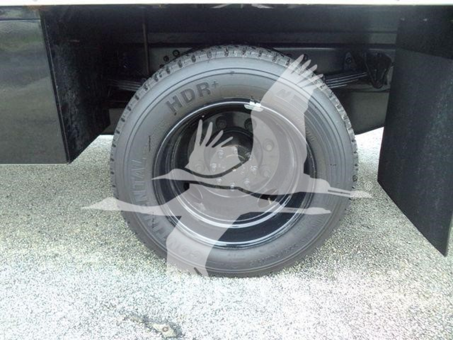 Truck wheel and tire visible under rear cargo area with HDLR branding on tire sidewall.