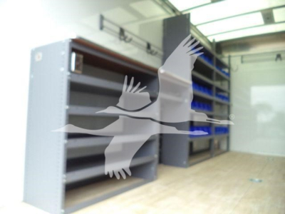 Trucks equipment storage area with metal shelving and cabinets in a showroom or garage.