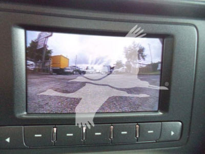 Vehicle display screen in a Chevrolet Silverado 6500HD showing a rear-view camera feed with a parking lot and vehicles.