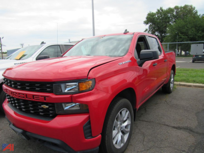 Chevrolet Silverado 1500 Limited pickup truck in red parked in a lot; front grille shows 'CHEVROLET' emblem; side badge 'Silverado' on front fender; black grille and headlight design visible.