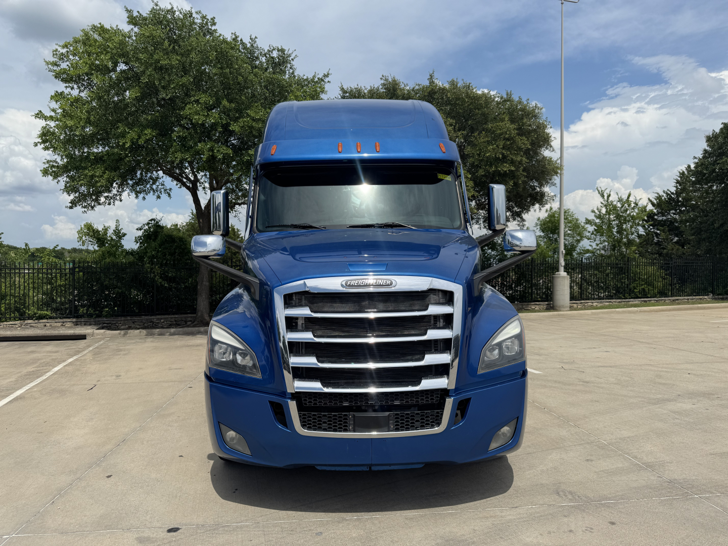 Front view of a blue 2022 Freightliner Cascadia 126 truck showing grille, headlights, and cab with side mirrors.