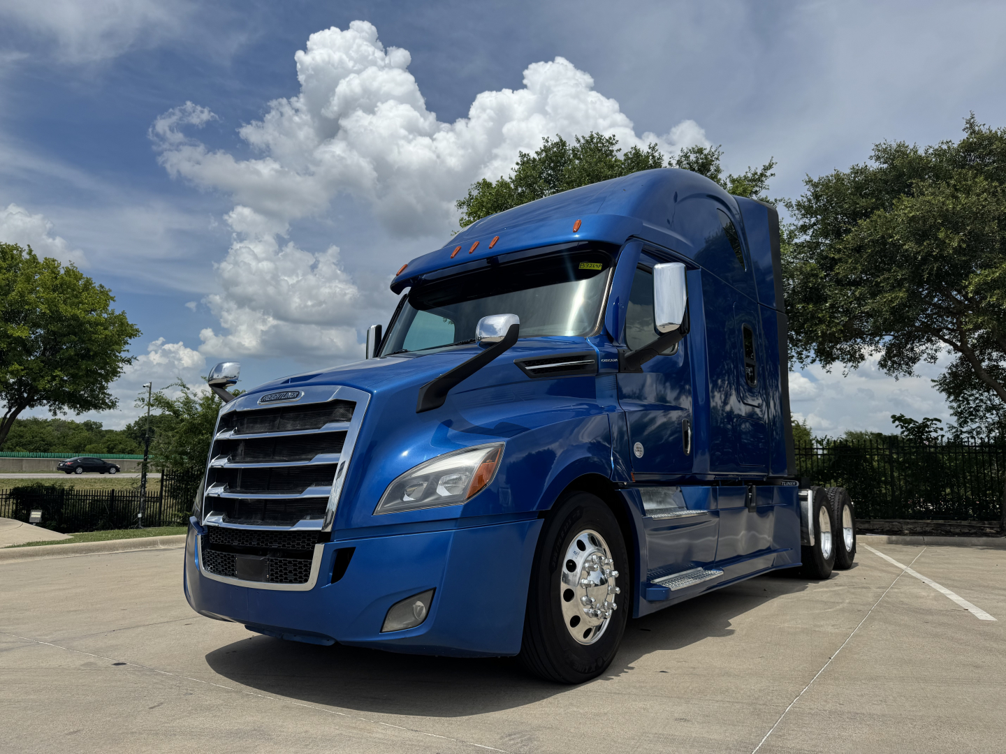 Truck image: blue 2022 Freightliner Cascadia 126 conventional sleeper tractor, side view showing front grille, cab mirrors, and dual rear axles.