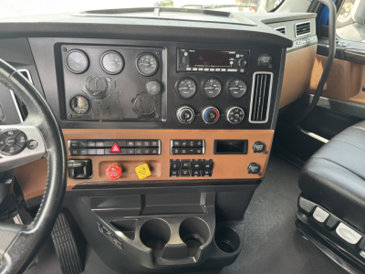 Truck cab dashboard interior with gauges, controls, and cup holders visible