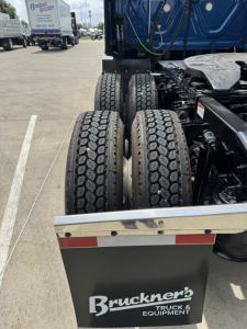 Dual rear tires on a Freightliner Cascadia 126 tractor showing wheel assembly and chassis with Bruckner's Truck & Equipment plate.