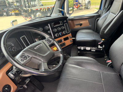Freightliner Cascadia 126 interior view showing steering wheel, dashboard with gauges, and brown-accent panels