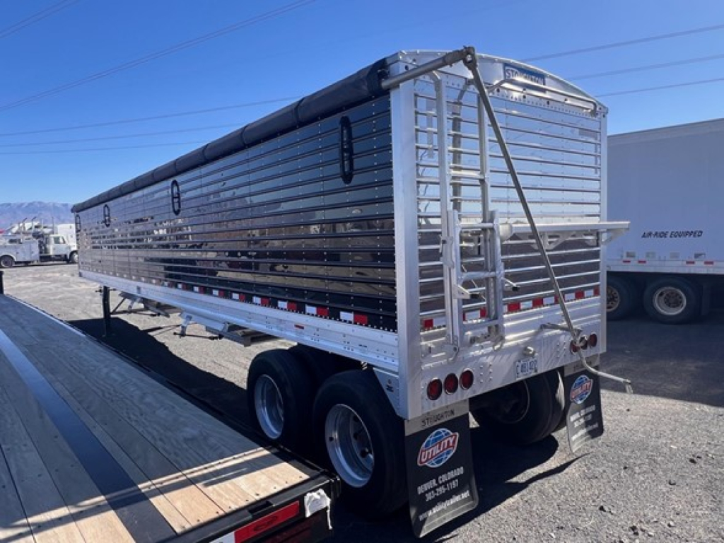 Stoughton grain trailer back view showing aluminum hopper with hinged rear gate and dual-axle wheels.