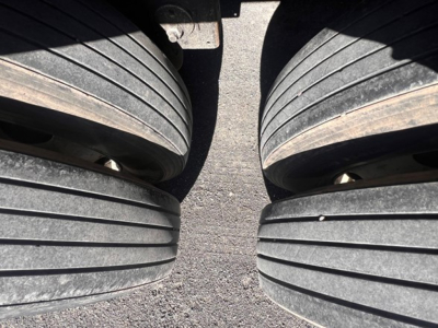 Trailer dual rear axles showing six large tires on a Stoughton grain trailer. No text visible.