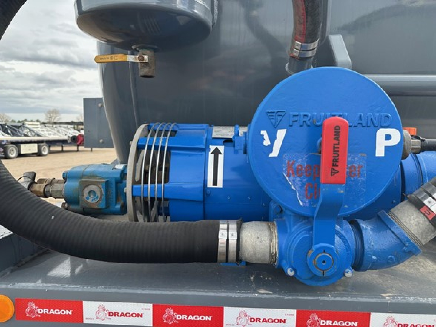 Blue Frumland vacuum tanker pump assembly with hose, valves, and arrows on the blue motor; Dragon branding visible on the base rail; P valve marked and connected hoses.